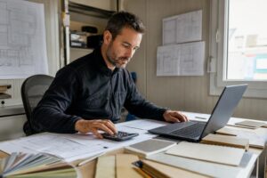 Artisan du bâtiment calculant le prix et la rentabilité d’un chantier