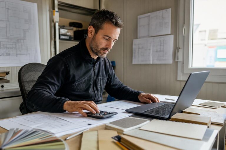 Artisan du bâtiment calculant le prix et la rentabilité d’un chantier